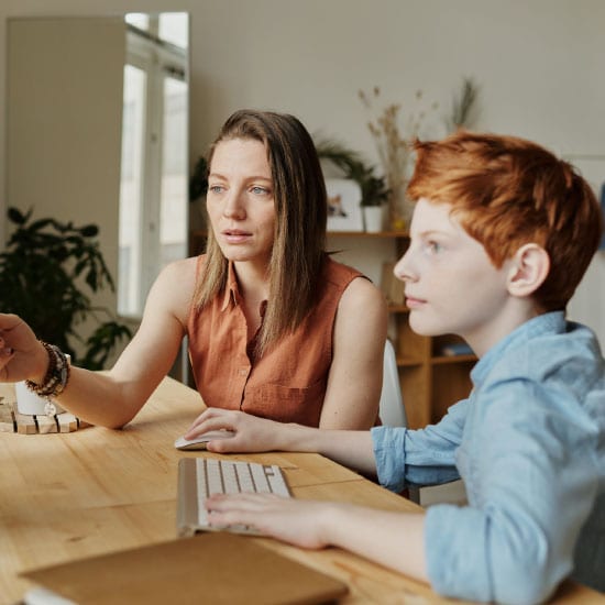 Parent helping child at computer
