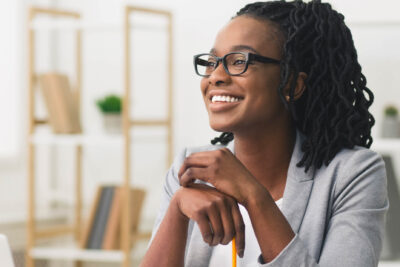 Young woman sitting at a desk and smiling.