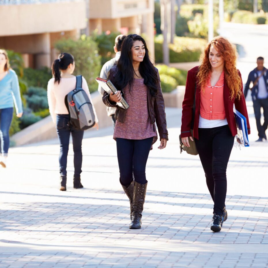 two-students-walking-on-campus-with-textbooks