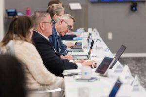 Chief business officers at long table with laptops