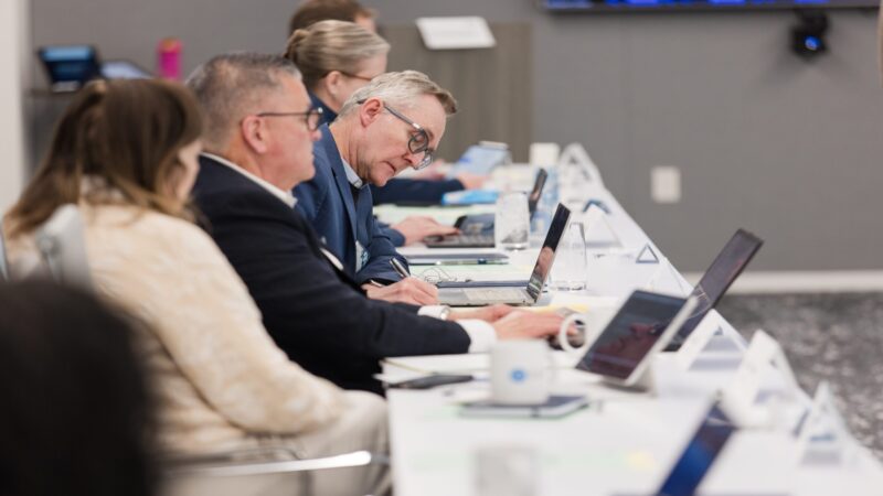 Chief business officers at long table with laptops